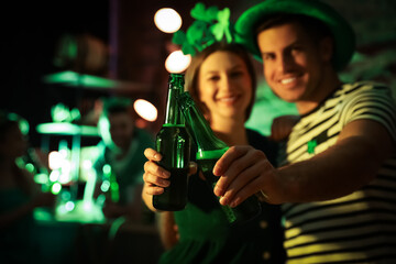 Wall Mural - Couple with beer celebrating St Patrick's day in pub, focus on hands