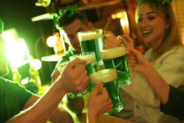 Wall Mural - People with beer celebrating St Patrick's day in pub, focus on hands