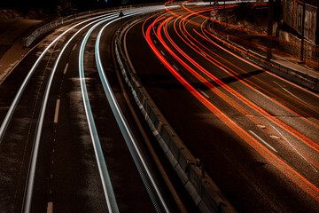 car road lights, taken at night in a spanish road, we can see red and white lights from cars an trucks