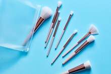 Assortment Of Makeup Brushes On Turquoise Surface