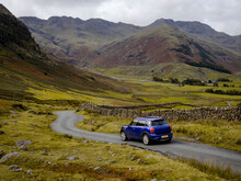 Car Driving Through Mountain Pass Of Lake District National Park