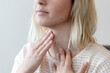 © Cavan Images - a young woman feels her thyroid gland