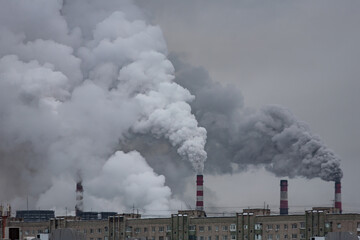 Wall Mural - industrial chimneys with heavy smoke causing air pollution on the gray smoky sky background