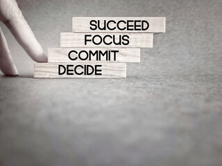 Wall Mural - Motivational and Inspirational Concept - Decide commit focus succeed text on wooden blocks background. Stock photo.