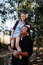 Daughter Posing On Dad's Shoulder At Park In Chula Vista