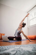 © Cavan Images - Athletic female practices yoga online indoors with laptop in home