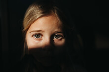Little Girl's Eyes In Bright Light With Black Background