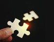 © surasak - Concept of business,hand holding a puzzle piece on puzzle background. Teamwork is collaborative effort of team to achieve goal or complete mission.