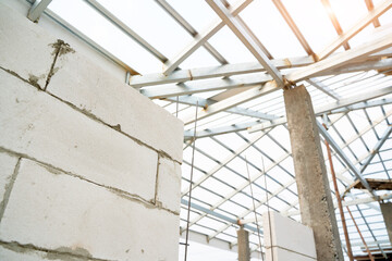 Poster - Aerated brick wall and steel roof frame in the construction site,Construction concept.
