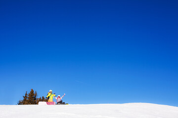 Wall Mural - two female friends with ski and snowboard equipment posing on the snow.