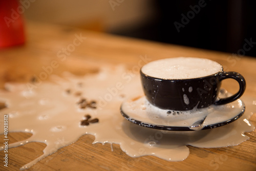 Close up barista pouring too much milk in coffee cup, making latte art