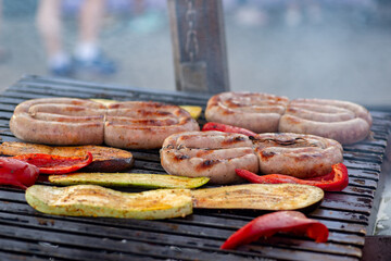 Wall Mural - Sausage and vegetables are grilled over an open fire. Street food. BBQ picnic