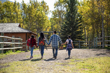 Family Holding Hands Hiking On Sunny Autumn Ranch