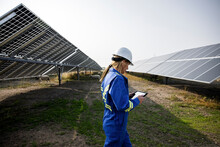 Technician Looking At Digital Tablet In Solar Farm