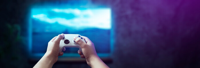 Fototapete - controller in man's hands playing video games in living room with rgb lights
