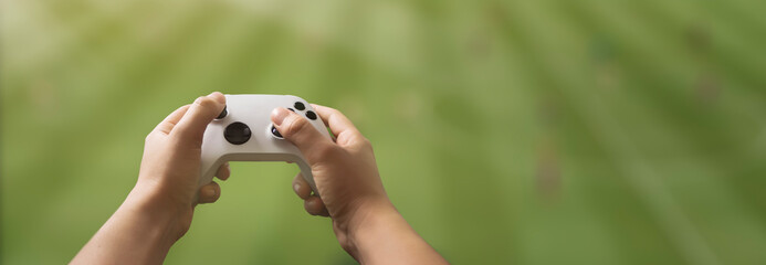 Fototapete - controller in the hands of man playing video games in the living room