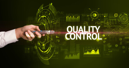 hand holding wireless peripheral with QUALITY CONTROL inscription, modern technology concept