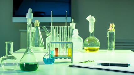 Poster - Laboratory glassware with multi-colored liquids. Laboratory glassware on table in lab. Concept - sale of laboratory approve. Used reagent tubes. Worker lab worker. Medical flasks of different shapes