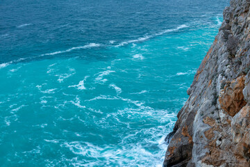 beautiful blue sea with big waves in a storm and rocks