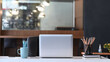© Prathankarnpap - Contemporary workplace with mock up laptop computer and office supplies on wooden office desk.