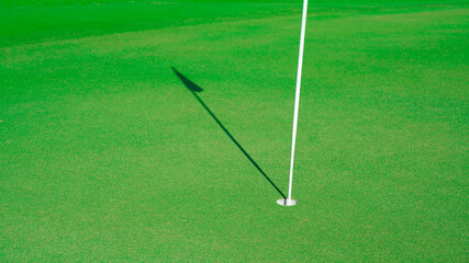 Wall Mural - Golf hole with the shadow of the flag
