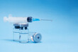 © Karyna - Ampoule, vial bottle, syringe on blue background. Vaccination concept, disease prevention. Health care, Coronavirus vaccine development
