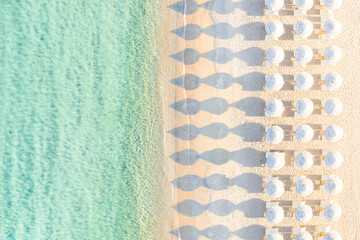 Sticker - View from above, stunning aerial view of an amazing empty white beach with white beach umbrellas and turquoise clear water during sunset. Mediterranean sea, Sardinia, Italy.