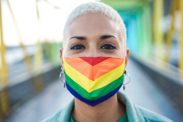 Wall Mural - Portrait of young lesbian wearing rainbow flag pride mask - Focus on face