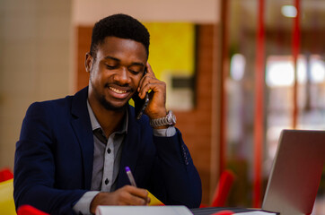 young handsome african businessman seriously taking notes about his business.