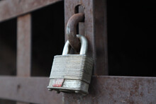 Closeup Shot Of Padlocks On A Rustic, Textured Metal Gate On A Blurred Background