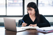 © EduLife Photos - Smiling Asian girl student wears wireless headphones write on the notebook to study language online watch and listen to the lecturer, webinar via video call e-learning at home, distance education