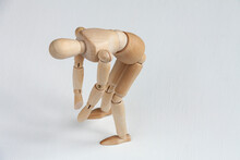 A Wooden Mannequin Doing Exercises On White Background