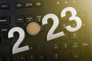 Wall Mural - black keyboard. close-up. on it are laid out numbers of metal 2023 in the center of the coin 2 euro