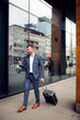 © Novak - Confident young businessman walking with luggage