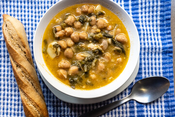 Poster - Chickpea stew with chard served in a white bowl with bread and spoon