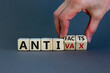© Dzmitry - Anti-facts or anti-vax symbol. Doctor turns a cube, changes words 'anti-vax' to 'anti-facts'. Beautiful grey background. Copy space. Business, medical covid-19 anti-facts or anti-vax concept.