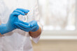© Natasha  - The hands of a doctor or nurse are carefully holding a bottle of coronavirus vaccine.