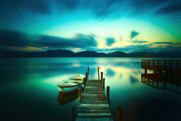 Wall Mural - Wooden pier or jetty and a boat on a lake sunset. Versilia Tuscany, Italy