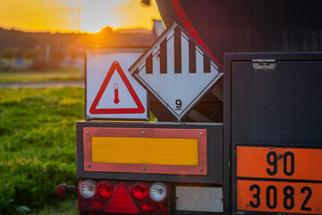 Wall Mural - High temperature liquid hazard and miscellaneous hazard label on dangerous goods tank truck.