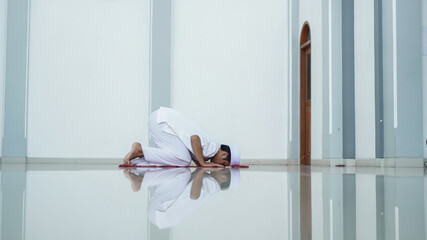 A portrait of an asian muslim man pray at mosque, the pray name is sholat, sujud movement on sholat