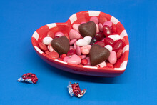Some Candy And Chocolat In An Heart Shape Bowl For Valentine's Day