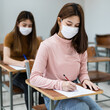 © EduLife Photos - Female teenager college students wears face mask and keep distance while studying in classroom and college campus to prevent COVID-19 pandemic