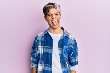 Poster - Young hispanic man wearing casual clothes sticking tongue out happy with funny expression. emotion concept.