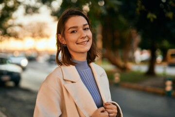 Young hispanic woman smiling happy standing at the city