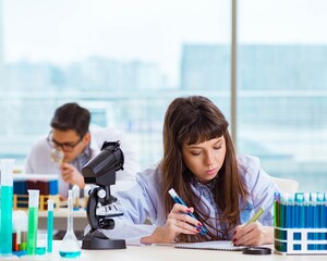 two chemists working in lab experimenting