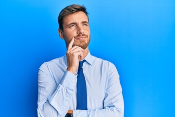 Handsome caucasian man wearing business shirt and tie serious face thinking about question with hand on chin, thoughtful about confusing idea