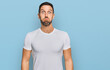 © Krakenimages.com - Handsome man with beard wearing casual white t shirt puffing cheeks with funny face. mouth inflated with air, crazy expression.