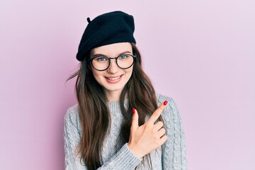 Sticker - Young beautiful caucasian girl wearing french look with beret smiling cheerful pointing with hand and finger up to the side