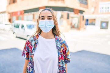 Wall Mural - Young beautiful blonde caucasian woman smiling happy outdoors on a sunny day wearing coronavirus safety mask