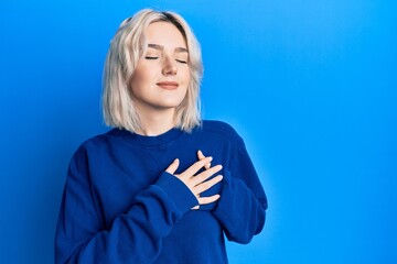 Sticker - Young blonde girl wearing casual clothes smiling with hands on chest, eyes closed with grateful gesture on face. health concept.